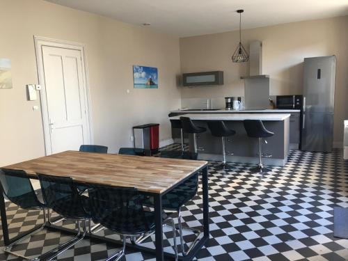 une cuisine avec une table et des chaises dans une pièce dans l'établissement la terrasse wimereusienne, à Wimereux