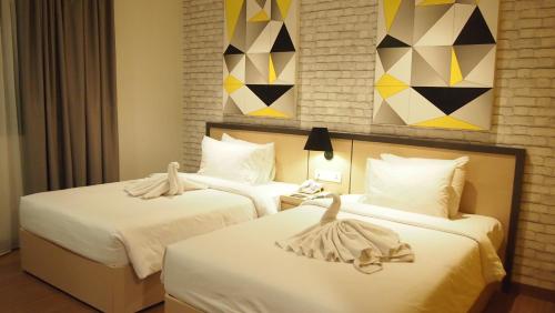 a hotel room with two beds with towels on them at Nite & Day Laguna Bintan in Tanjung Pinang 