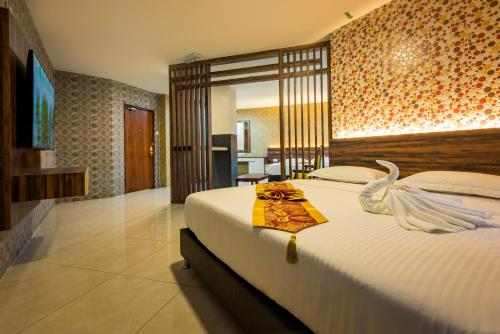 ein Schlafzimmer mit einem großen Bett mit einem Schwan darauf in der Unterkunft AB Inn Hotel in Kulai