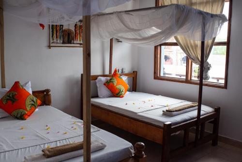 a bedroom with two bunk beds and an umbrella at Mocco Beach Villa in Kendwa