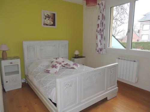 um quarto com uma cama branca com almofadas e uma janela em BRUYERE D'ANDAINE em Bagnoles de l'Orne