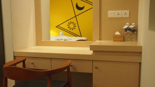a mirror in a bathroom with a chair and a sink at Nite & Day Laguna Bintan in Tanjung Pinang 