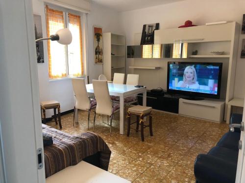 sala de estar con mesa con sillas y TV en Casa sul Mare Giulia Zoagli, en Zoagli