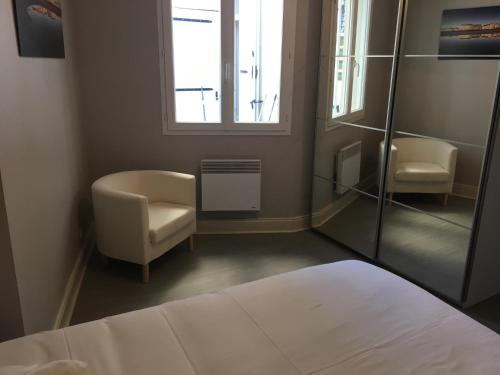 une chambre avec un lit, une chaise et une fenêtre dans l'établissement la terrasse wimereusienne, à Wimereux