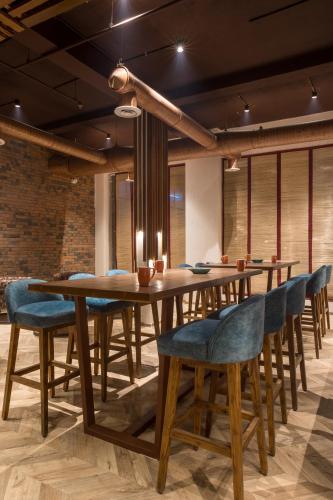 a dining room with a wooden table and blue chairs at Centre Point Navi Mumbai in Navi Mumbai