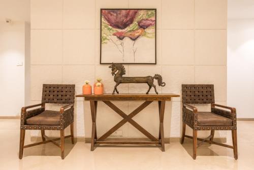 a table with two chairs and a statue of a horse on it at Centre Point Navi Mumbai in Navi Mumbai