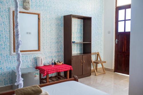 a room with a table and a mirror and a bedroom at Mocco Beach Villa in Kendwa