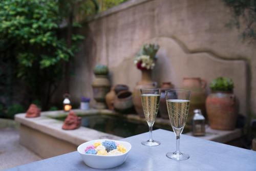 two glasses of champagne and a bowl of food on a table at Hôtel Particulier Le 28 - Spa & Art Luxury Design by Alain Ducasse in Aix-en-Provence