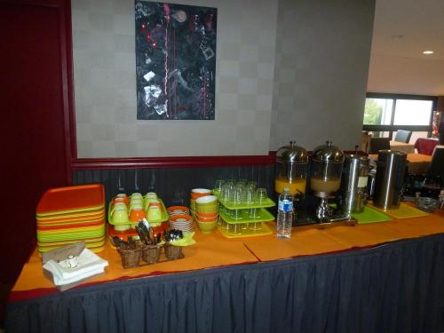 una mesa con platos y tazas encima en Hotel Beau Rivage, en Le Vivier-sur-Mer