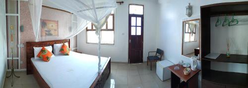 a bedroom with a bed with a canopy at Mocco Beach Villa in Kendwa
