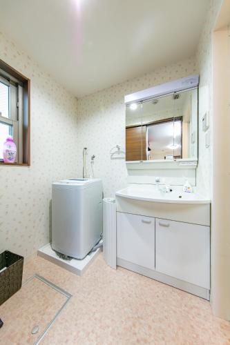a bathroom with a sink and a mirror at Apartment Heights HANA in Sakai