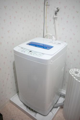 a white toilet in a room with a wall at Apartment Heights HANA in Sakai