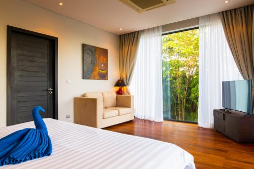 ein Schlafzimmer mit einem Bett mit einem blauen Schwan darauf in der Unterkunft Amazing 5br, Seaview private PoolVilla by Intira Villas in Rawai Beach