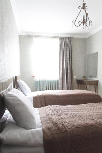 a bedroom with two beds and a window with a chandelier at Sunny Mountain House in Stepantsminda