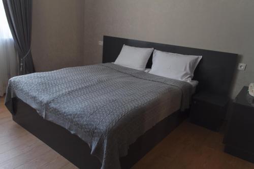 a bedroom with a large bed with two pillows at Sunny Mountain House in Stepantsminda