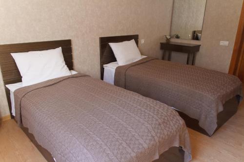 a hotel room with two beds and a table at Sunny Mountain House in Stepantsminda