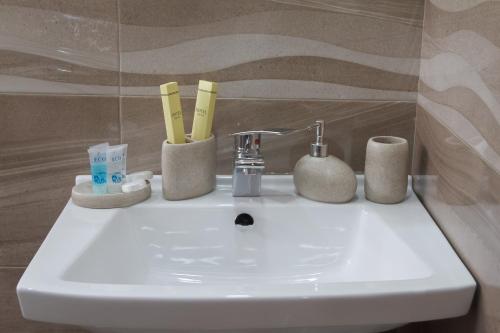 a bathroom sink with toothbrushes and toothpaste on it at Sunny Mountain House in Stepantsminda