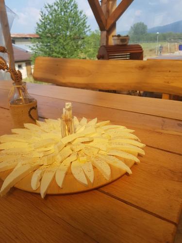 a wooden cutting board with a flower on a table at BIO Farma & Penzión Zlatý Hýľ in Nováčany