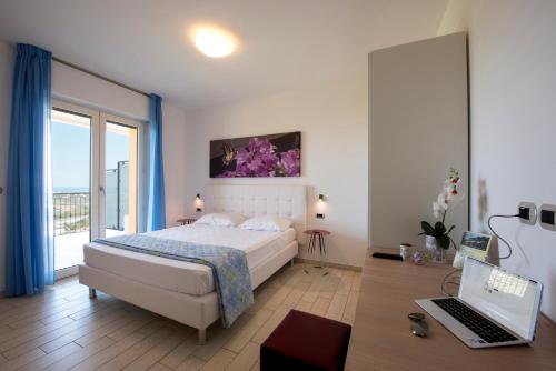 マルティンシクーロにあるIl Giardino Sul Mareのベッドルーム1室(ベッド1台、ノートパソコン付)