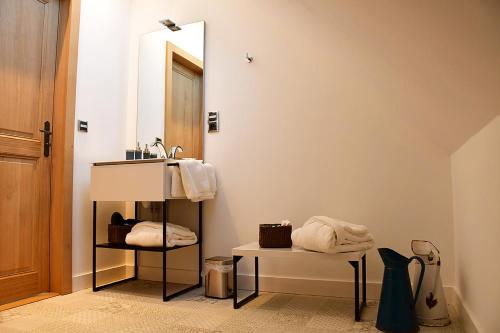 La salle de bains est pourvue d'un lavabo et d'un miroir. dans l'établissement Domaine de La Lochetière Chambres d'hôtes, à Normandel