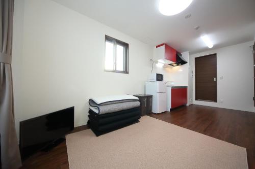 a living room with a black chair and a kitchen at Apartment Heights HANA in Sakai