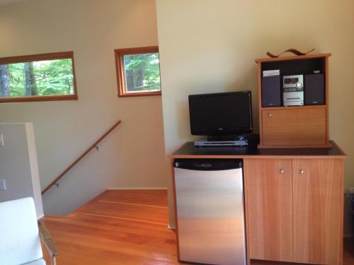 a room with a desk with a tv and a computer at Hyphocus Inn in Ucluelet