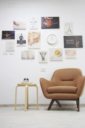 a chair and a table in front of a wall with pictures at LAMITA in Majdal Shams