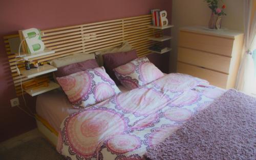 a bedroom with a bed with pink sheets and pillows at Varkiza Seaside Penthouse with Private Roof Deck in Vari