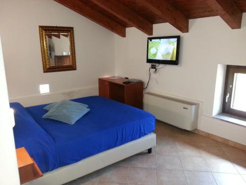 a bedroom with a bed and a tv on the wall at Country House Casale D'Orio in Ascea