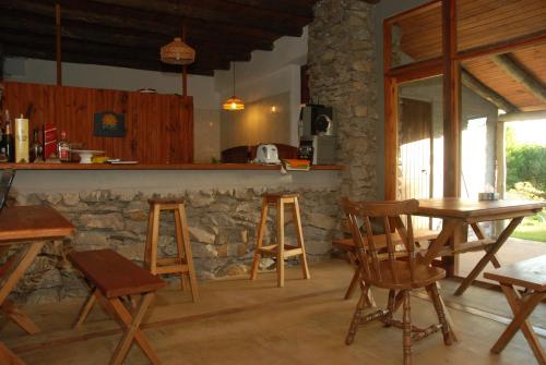 a kitchen with a table and chairs and a stone wall at Hotel El Refugio nudista naturista opcional in Chihuahua