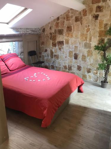 a bedroom with a red bed and a stone wall at Love Room Jacuzzi Croisette in Cannes