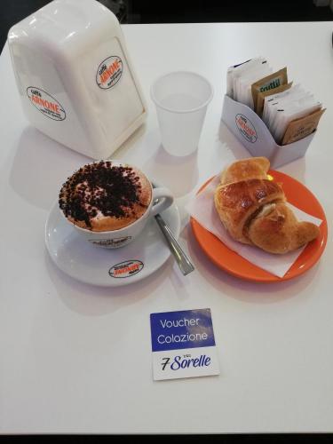 a table with a cup of coffee and a plate of pastries at "7 SORELLE B&B" camere in pieno centro città con bagno privato, FREE HIGH SPEED WI-FI, NETFLIX in Cosenza