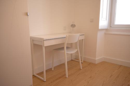 a white desk with a chair next to a window at Double Suite by the Ocean in Paço de Arcos