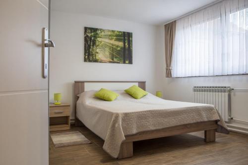 a bedroom with a bed with two lime green pillows at Apartment Vir with free private parking in Karlovac