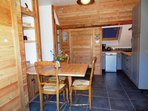 a kitchen with a wooden table and chairs at Gite de Champ Chaulier in Crots