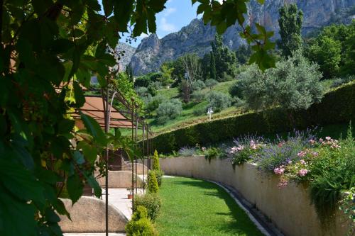 a garden with mountains in the background at Hôtel Le Colombier in Moustiers-Sainte-Marie