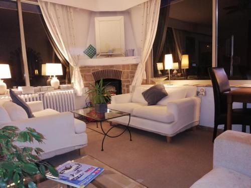 a living room with white couches and a fireplace at Hotel Cayrons Vence & St Paul de Vence in Vence