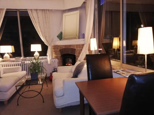 a living room with white furniture and a fireplace at Hotel Cayrons Vence & St Paul de Vence in Vence