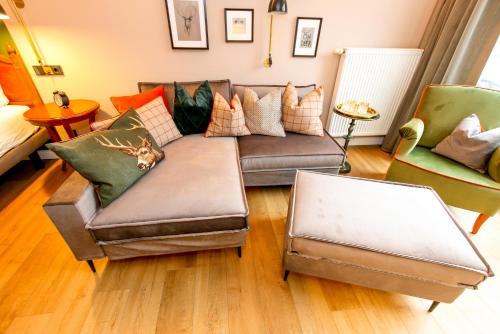 a living room with a couch and two chairs at Nordseehotel Kröger in Langeoog