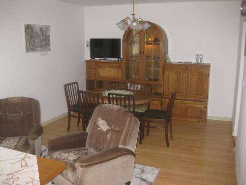 a dining room with a table and chairs and a tv at Ferienwohnung mit Aegidienblick in Oschatz