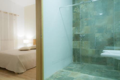 ein Bad mit einer Dusche, einem Waschbecken und einem Bett in der Unterkunft Quinta de Trancoso in Carnicãis
