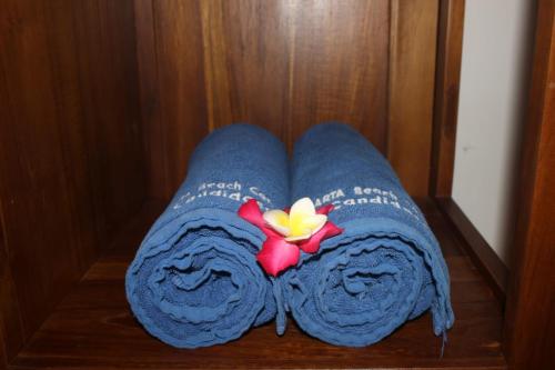 two blue towels with a flower on top of them at Amarta Beach Cottages in Candidasa