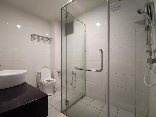 a bathroom with a glass shower and a toilet at ExcluSuites Malacca @ The Wave Residence in Melaka