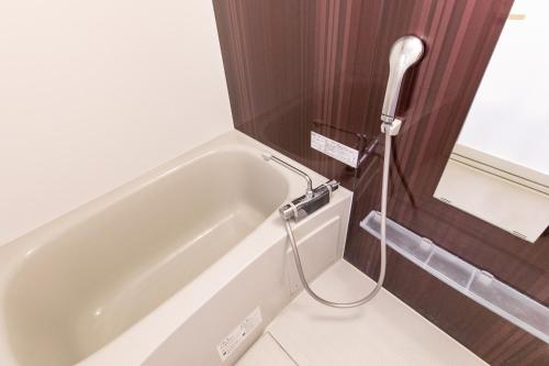 y baño con ducha y bañera. en Condominium Hotel Likka in Nago, en Nago