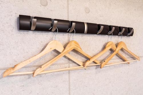 a bunch of wooden hangers hanging from a rack at Condominium Hotel Likka in Nago in Nago