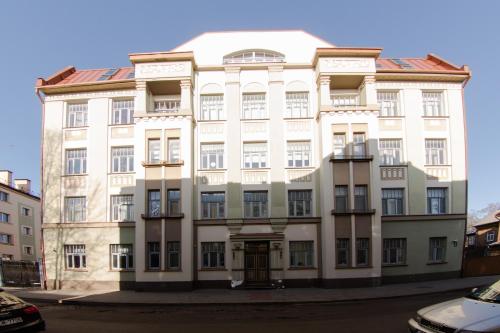 un grand bâtiment blanc dans une rue dans l'établissement Suitu apartments, à Liepāja