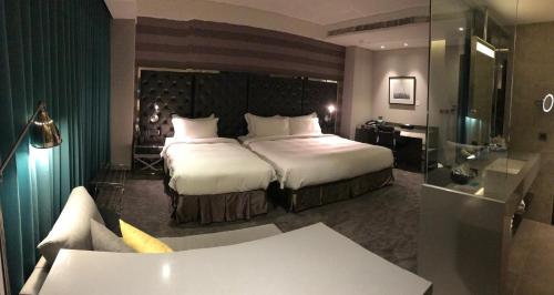 a hotel room with a large bed and a bathroom at Starhaus Hotel in Kaohsiung