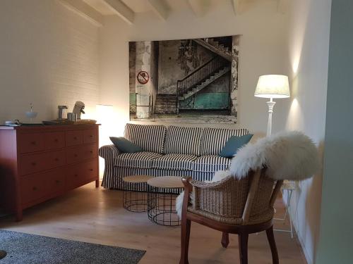 a living room with a couch and a chair at Beej Potters in Weert