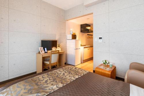 1 dormitorio con cama, escritorio y nevera en Condominium Hotel Likka in Nago, en Nago