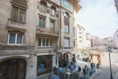 a building on a street with people standing in front of it at Color Apartments Nicolae Tonitza St in Bucharest